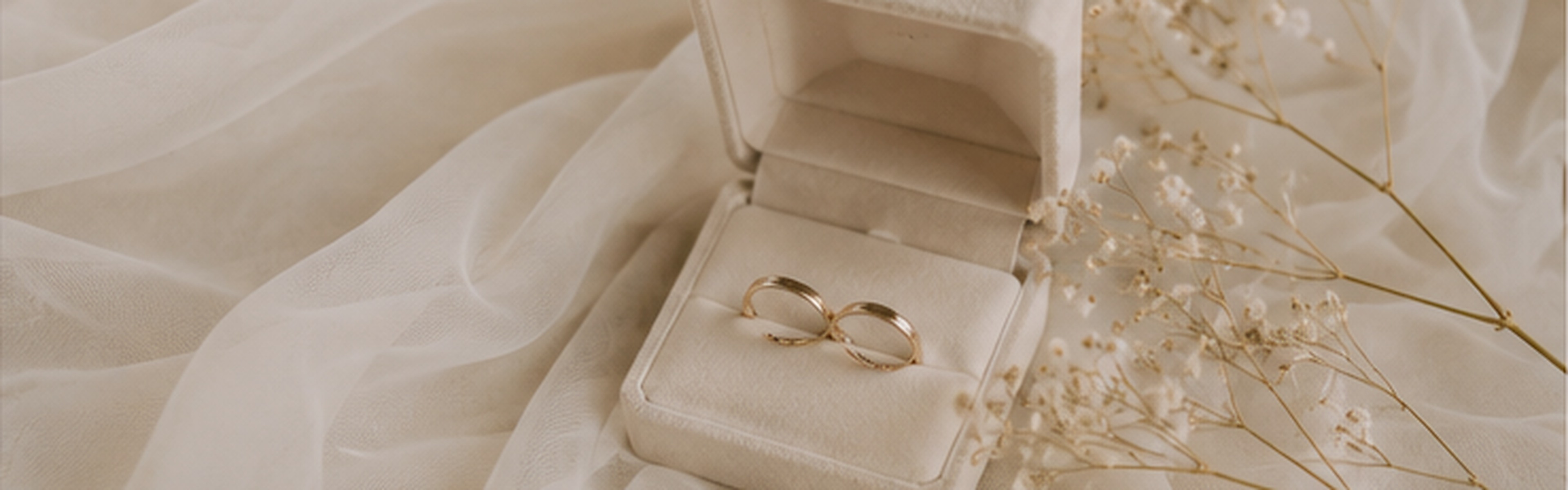 Wedding rings and bridal fabric in soft natural light