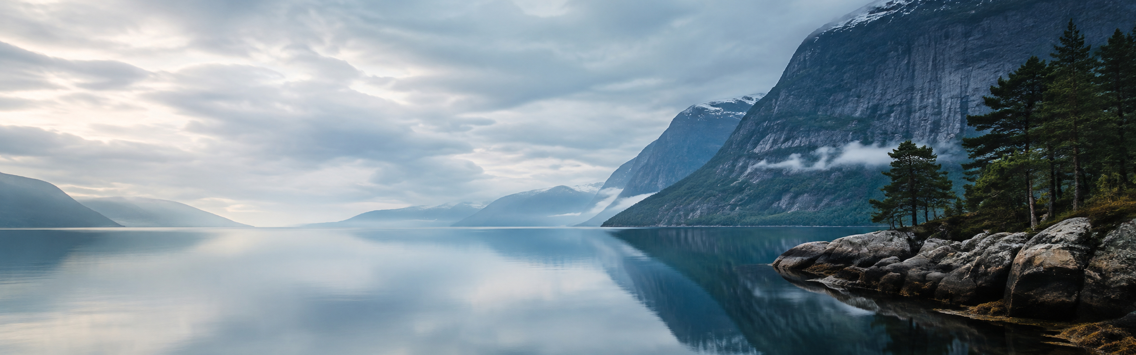 Majestic Norwegian fjord with mist, mountains and a tall waterfall