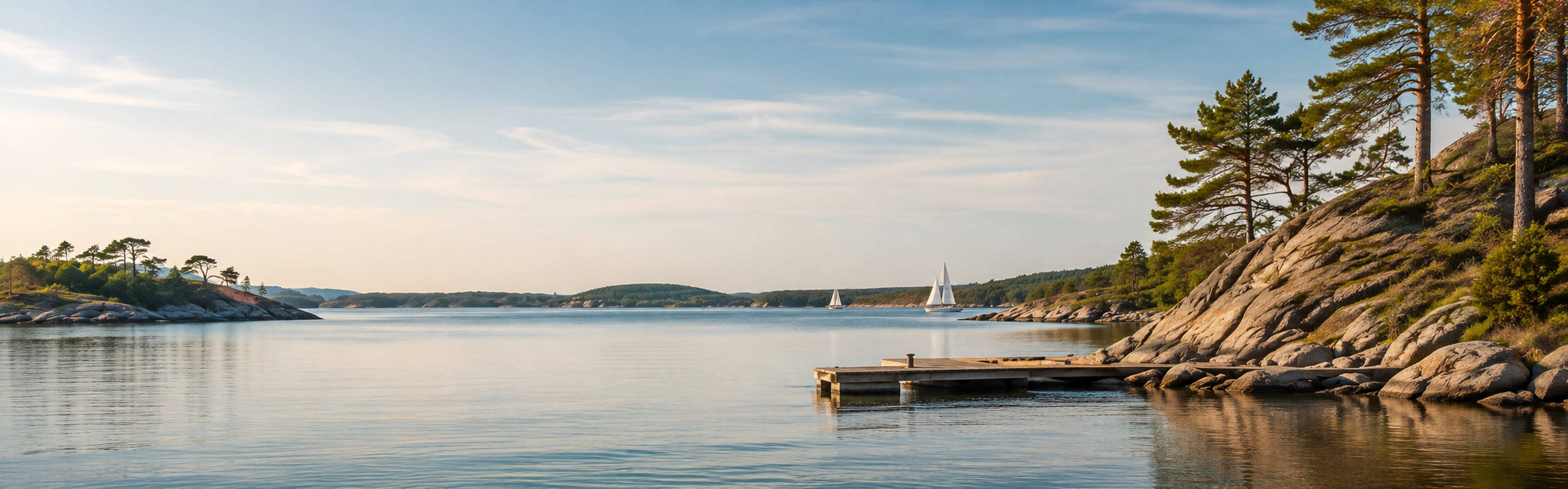 Calm Swedish archipelago bay with pine shoreline and a quiet jetty